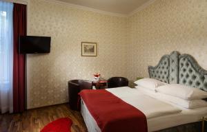 um quarto de hotel com uma cama e uma televisão em Hotel Urania em Viena