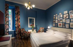 a bedroom with a bed and a blue wall at Hotel Urania in Vienna