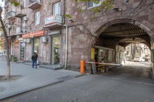 a man walking through an archway into a building at Stay Inn Apartments at Mashtots Avenue 5A in Yerevan