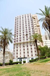 a large building with palm trees in front of it at Dar Al Bayan Hotel in Mecca