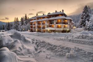 a large building covered in snow in the snow at Mountain Lake Hotel in Smolyan