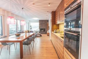 a kitchen with a long wooden table and chairs at Glücksthaler by AA Holiday Homes - SchladmingDachstein in Aich