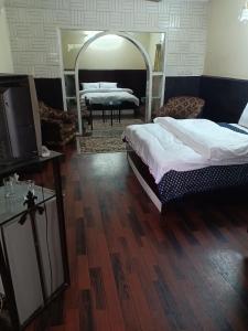 een slaapkamer met 2 bedden en een grote spiegel bij New Islamabad Guest House in Islamabad