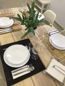 uma mesa com placas brancas e uma planta sobre ela em Mon Residence Sant Jeroni em Manresa