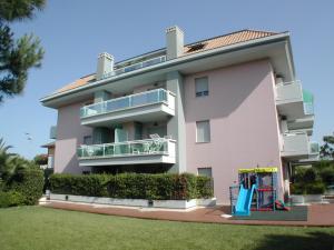 ein großes rosafarbenes Gebäude mit einem Spielplatz davor in der Unterkunft Appartamento Mediterraneo in San Benedetto del Tronto