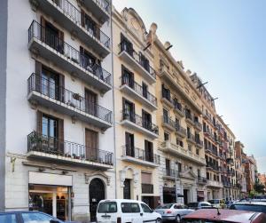 a large building with cars parked in front of it at Apartamento Sant Gervasi in Barcelona