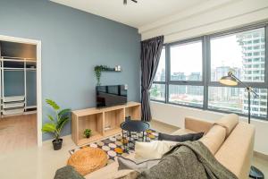 uma sala de estar com um sofá e uma televisão em Arte Plus by Cobnb KLCC em Kuala Lumpur
