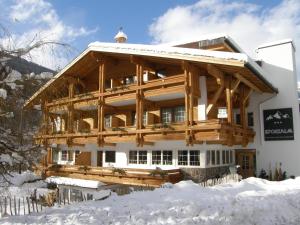 a log home with snow on the ground at Sportalm in Sölden