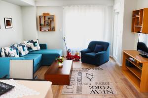 een woonkamer met een blauwe bank en een blauwe stoel bij Foxxy Luxury Apartments in Skopje