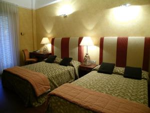a hotel room with two beds and two lamps at AmbientHotels Panoramic in Rimini