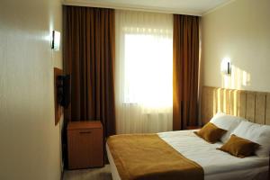 a hotel room with a bed and a lamp at Lion City Hotel Ankara in Ankara