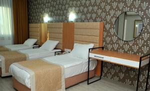 a hotel room with two beds and two lamps at Lion City Hotel Ankara in Ankara