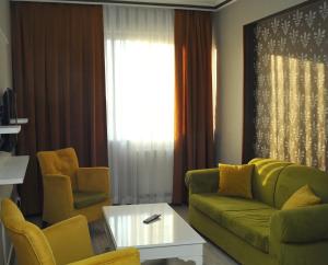 a living room with a green couch and two chairs at Lion City Hotel Ankara in Ankara