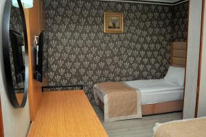 Lion City Hotel Ankara في أنقرة: غرفة صغيرة بسرير وطاولة صغيرة