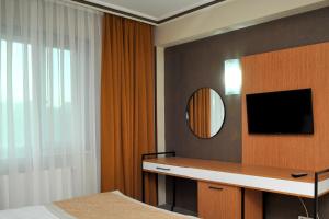 Lion City Hotel Ankara في أنقرة: غرفة نوم مع مكتب ومرآة وسرير