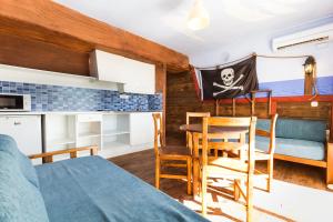 a room with a bed, chair and a tv at Pirates Village in Santa Ponsa