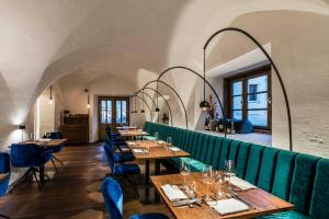un restaurante con mesas de madera y sillas azules en Flurin Suites, en Glorenza