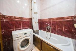 a bathroom with a washing machine and a bath tub at Apartments on Karla Marksa in Mogilev