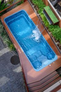 a swimming pool with a water fountain on a wooden deck at VELA be Bangkok Ratchathewi in Bangkok