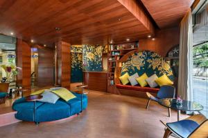 a living room with a blue couch and yellow pillows at VELA be Bangkok Ratchathewi in Bangkok