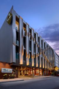 a rendering of a building at dusk at VELA be Bangkok Ratchathewi in Bangkok