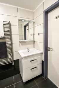 ein Badezimmer mit einem weißen Waschbecken und einem Spiegel in der Unterkunft Dominik Panzió in Budapest