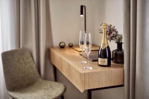 a table with a bottle of champagne and two wine glasses at Hotel OLDINN in Český Krumlov