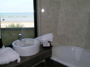 a bathroom with a sink and a bath tub and a window at AmbientHotels Panoramic in Rimini