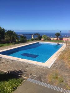 a swimming pool with the ocean in the background at Ocean View Cottage in Ponta do Pargo