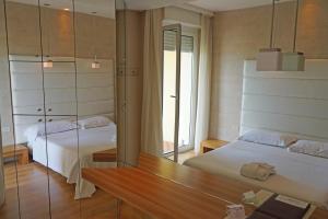 a bedroom with two beds and a mirror at AmbientHotels Panoramic in Rimini