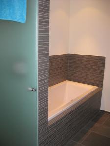 a bath tub in a bathroom with brown tile at Pradin 1 in Arosa