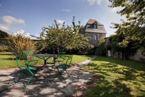 ein Tisch und Stühle vor einem Haus in der Unterkunft Les Cottages du Château du Rozel in Le Rozel