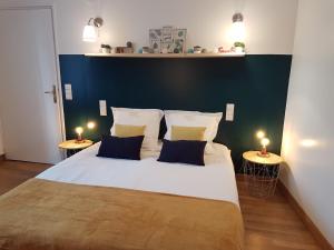 ein Schlafzimmer mit einem großen weißen Bett mit zwei Lampen in der Unterkunft Les Cottages du Château du Rozel in Le Rozel