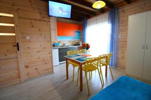 cocina con mesa y sillas y TV en Morska Przygoda en Rewal