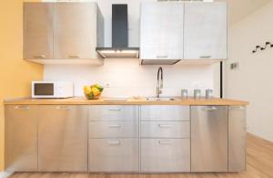 a kitchen with stainless steel cabinets and a microwave at Residence delle Erbe by Studio Vita in Bologna