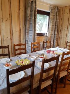 una mesa con sillas y platos de comida. en La Pinéguette maison 12 personnes décoration chalet/ sauna 4 personnes, en La Bresse