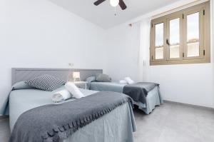 a bedroom with two beds and a window at Alcudia Apartments in Port d'Alcudia