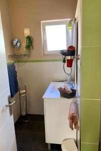 a small bathroom with a white sink and a window at Casa La Paloma in El Jaral +30 photos
