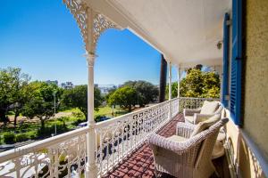 a balcony with chairs and a view of a park at The Walden House in Cape Town