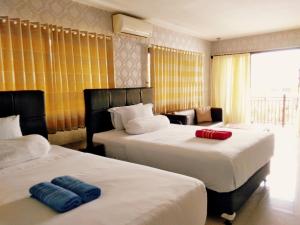 una camera d'albergo con due letti e un divano di Jos & Hanny Homestay a Batu