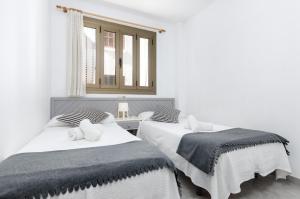 dos camas sentadas una al lado de la otra en un dormitorio en Alcudia Apartments, en Puerto de Alcudia