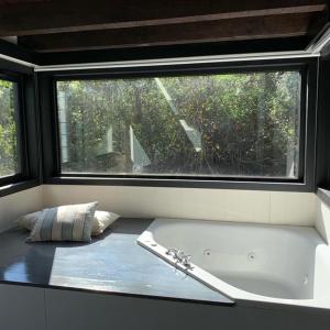 a bath tub in a room with a window at Sieteflores Hosteria De Montaña in San Martín de los Andes