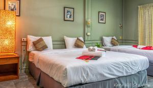 a hotel room with two beds with a teddy bear on top at Hotel Kata Hill Sea View in Kata Beach