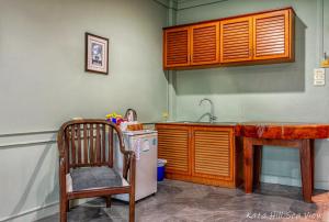 a kitchen with a counter and a sink and a chair at Hotel Kata Hill Sea View in Kata Beach