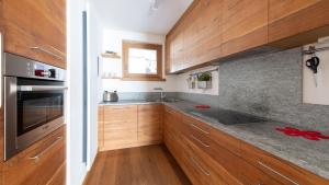 una cucina con armadietti in legno ed elettrodomestici in acciaio inossidabile di Italianway - Castellazzi 14 Marmotta a Bormio