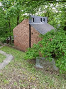 ein Backsteingebäude mit einem Dach darüber in der Unterkunft Wood House in Blaimont