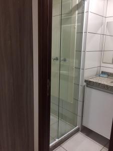 La salle de bains est pourvue d'une douche avec une porte en verre. dans l'établissement Fortaleza Beach Class Apartments Tower 2, à Fortaleza