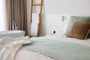 a bedroom with a white bedspread and pillows at Els Pins Resort & Spa in San Antonio Bay