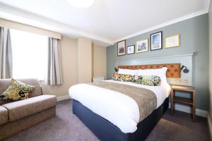 a hotel room with a large bed and a couch at The St George and Dragon by Innkeeper's Collection in Topsham