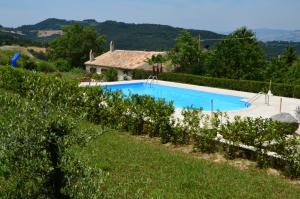 a large swimming pool in a yard with a house at Agriturismo Girolomoni - Locanda in Isola del Piano